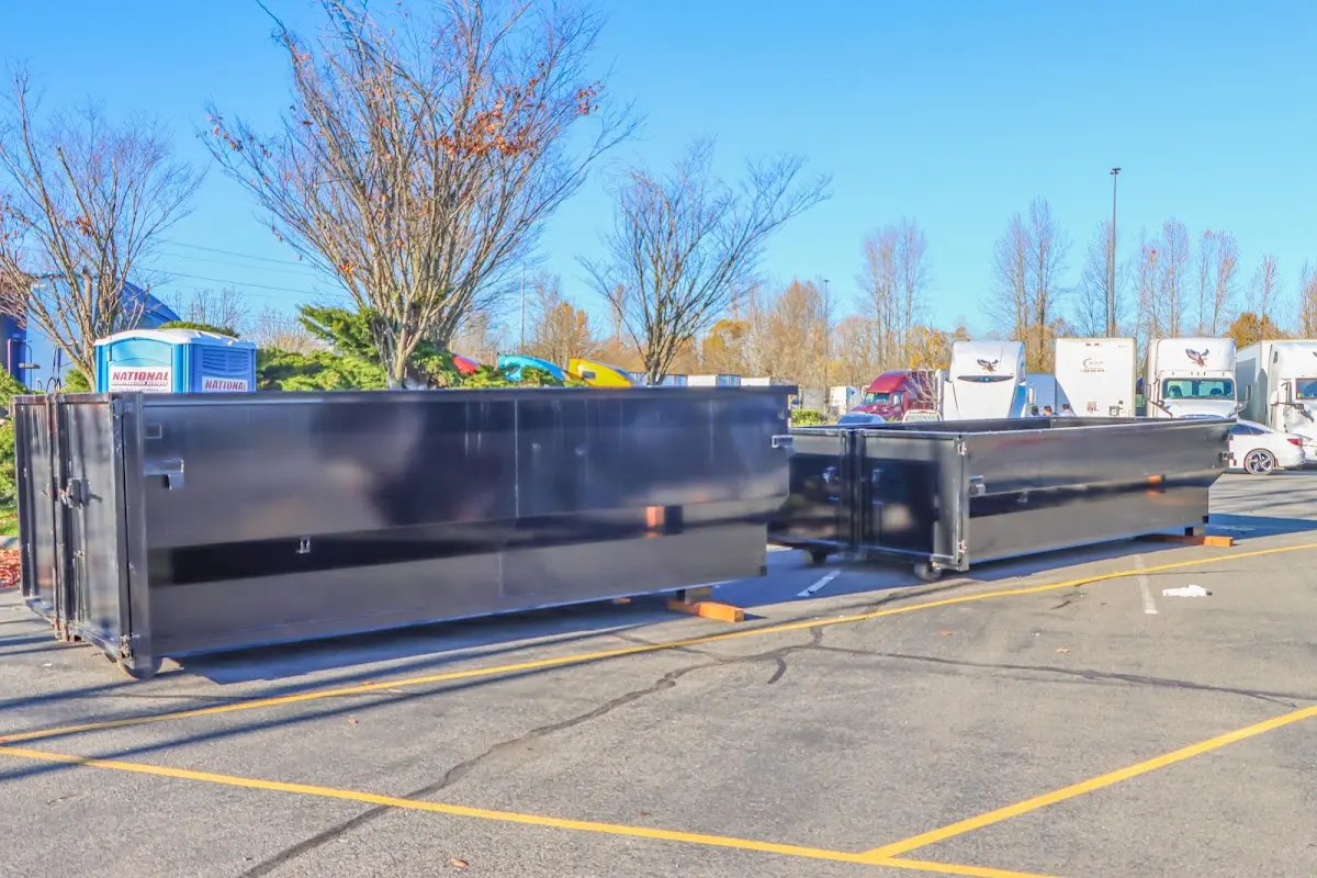 Professional dumpster rental service with roll-off container on residential driveway in Orchard Mesa